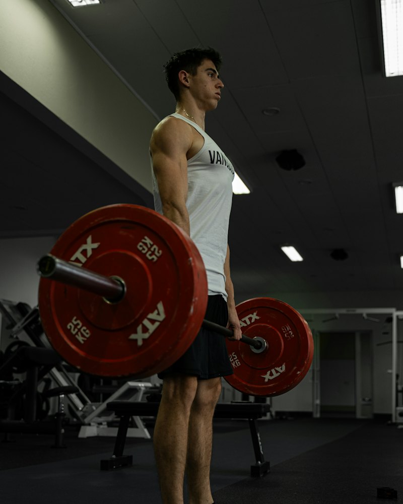 Karanlık bir salonda halter kaldıran sporcu